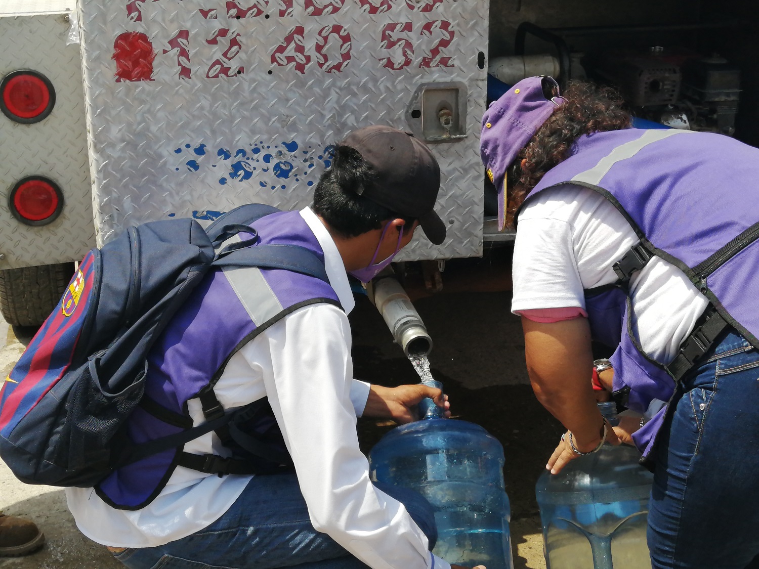 Personas llenando garrafones
